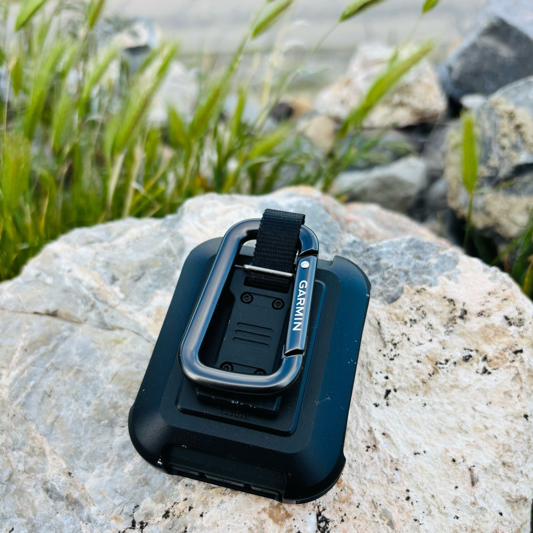 Garmin inReach Messenger Cradle Mount sitting on a rock showing carabiner and mounting system