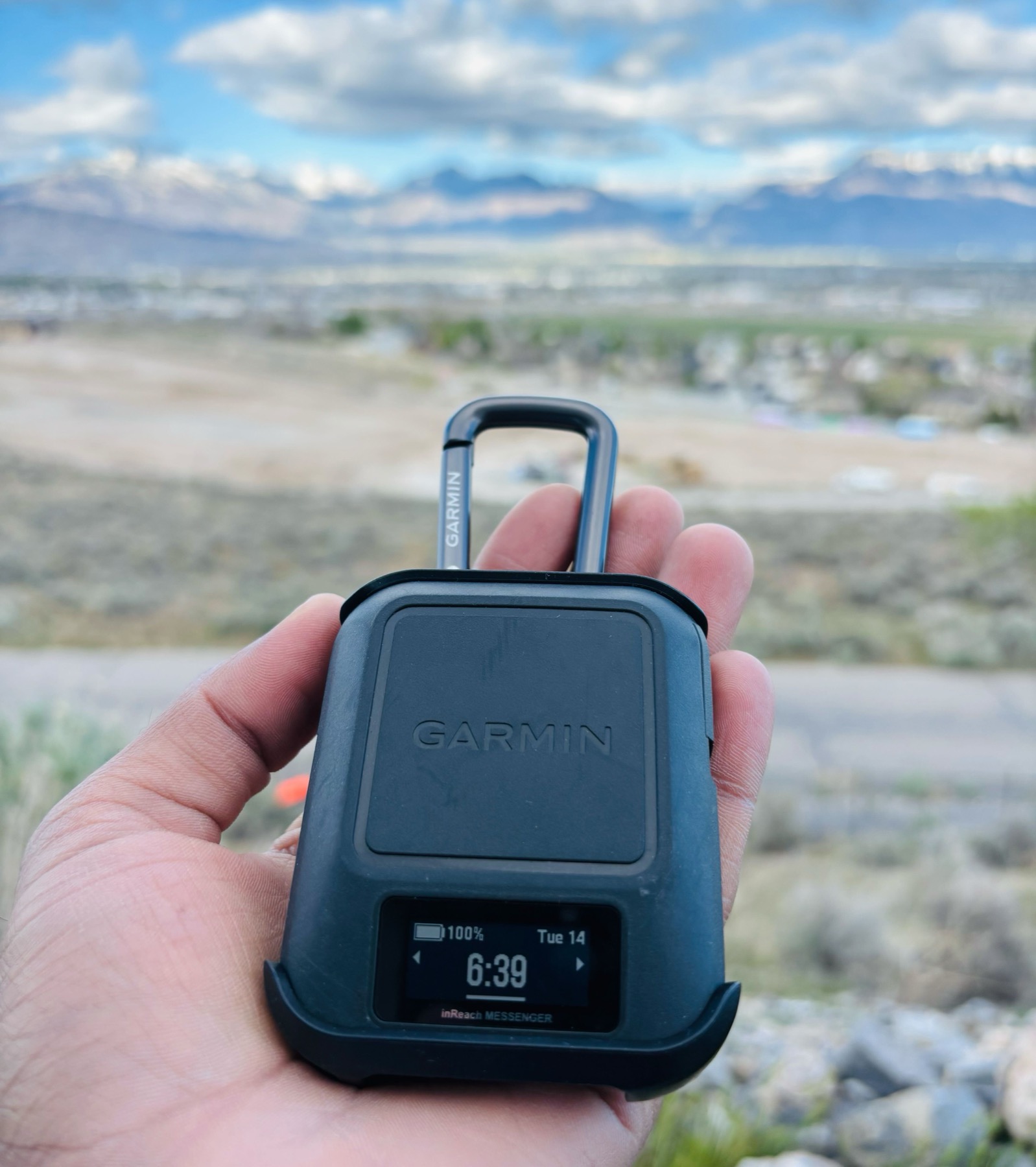 Garmin inReach Messenger held in hand against Utah mountain backdrop