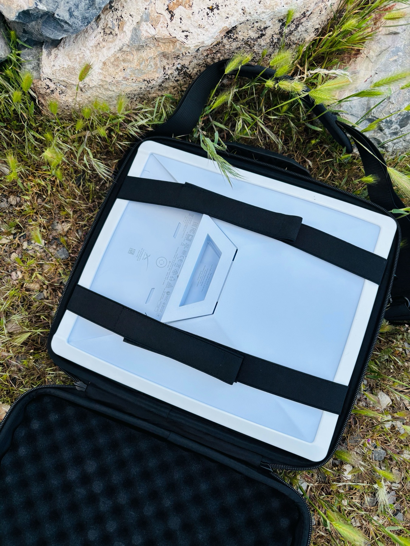 Yedralune case open showing Starlink Mini dish secured with elastic straps, foam interior