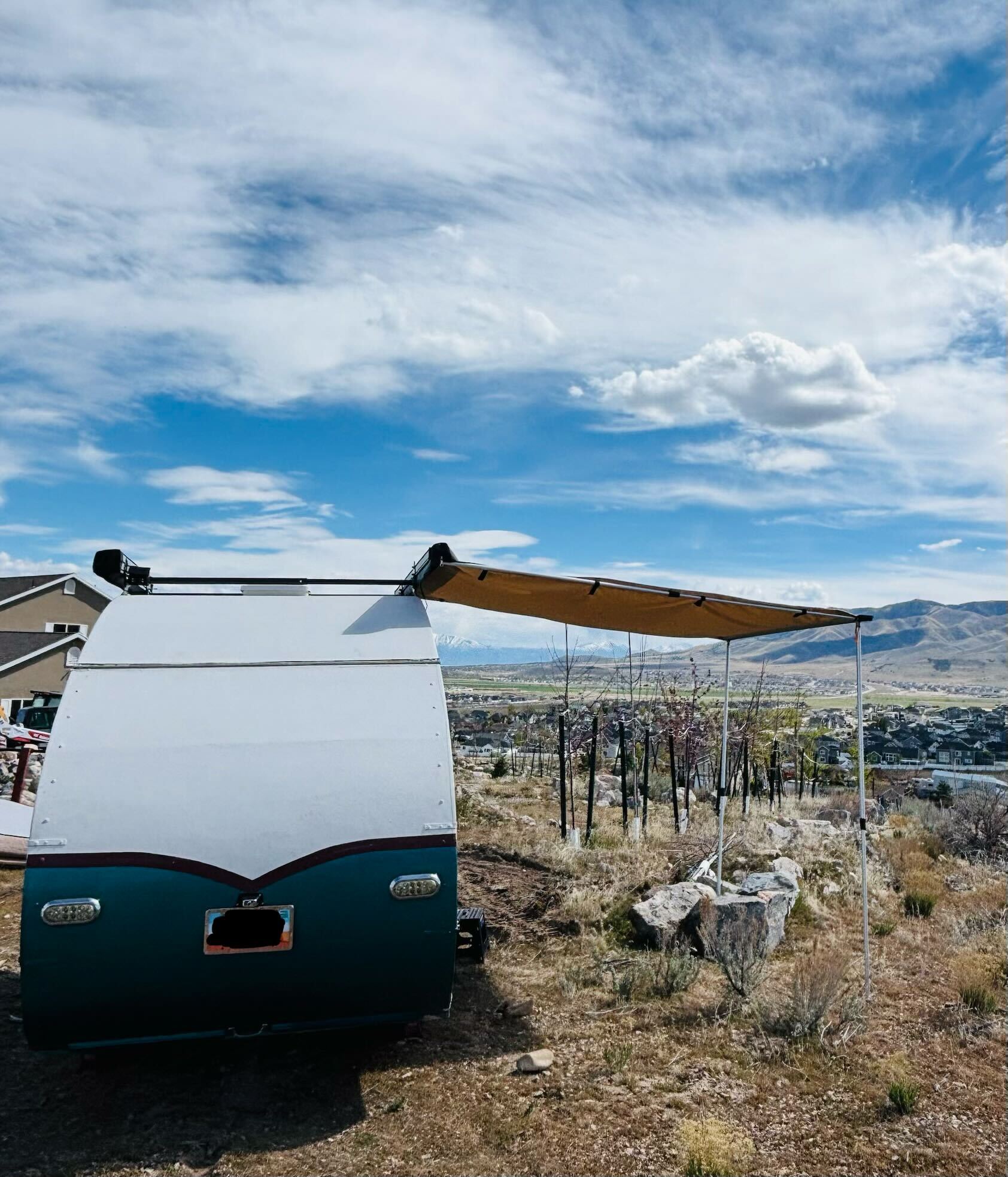 Pearl parked on a hillside with awning deployed and valley view