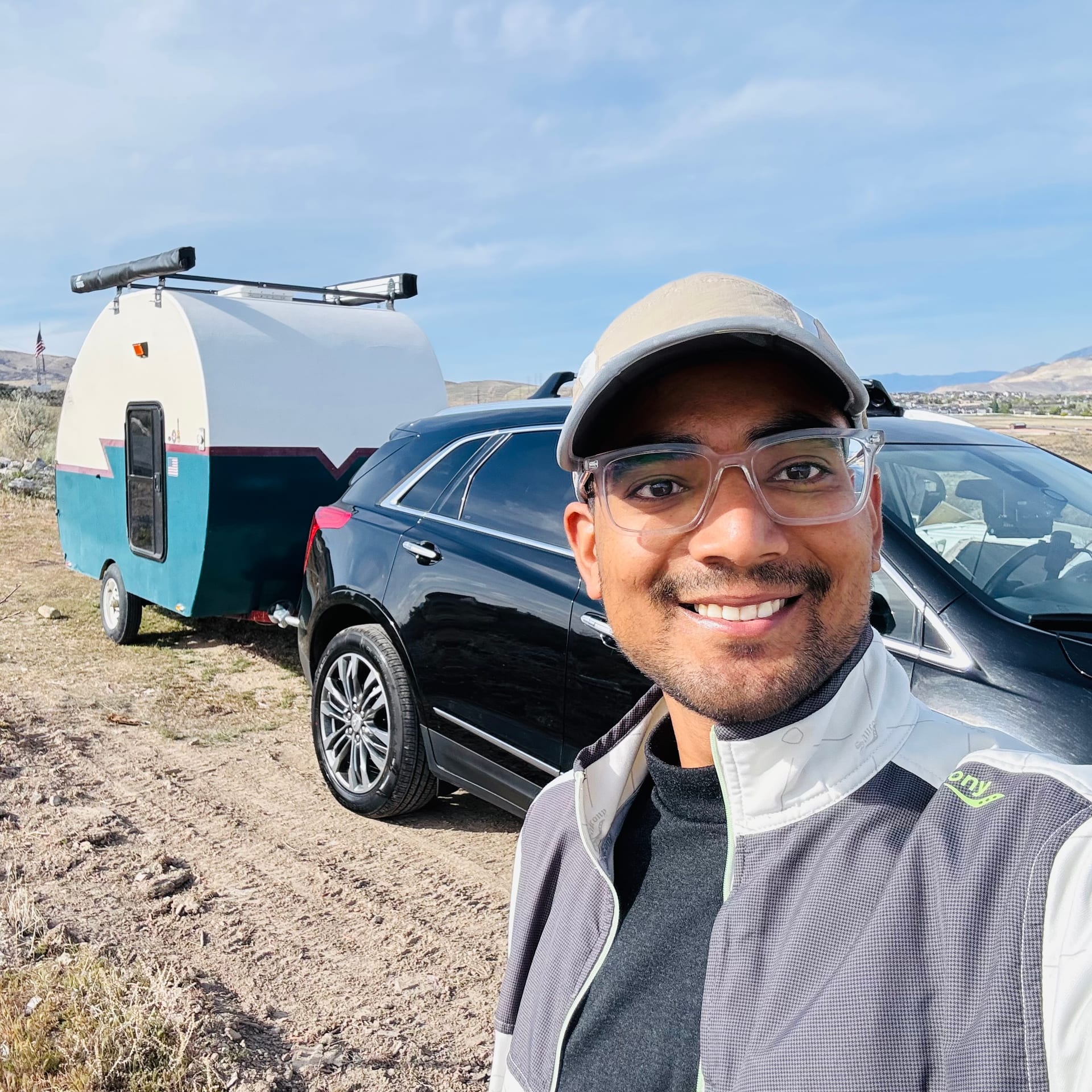 Selfie with Pearl the teardrop camper hitched to a black Cadillac XT5, ready for the maiden trip